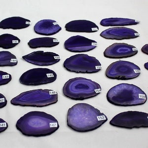 May include: A collection of 19 purple agate slices, each with unique banding patterns. The slices are numbered 140-164.