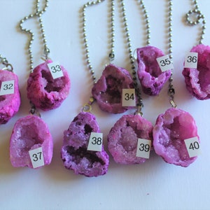 May include: Nine pink and purple crystal geodes on silver chains with numbers 32, 33, 34, 35, 36, 37, 38, 39, and 40.