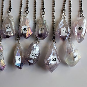May include: Ten iridescent purple crystal pendants with silver chains. The crystals are numbered 44 through 54.