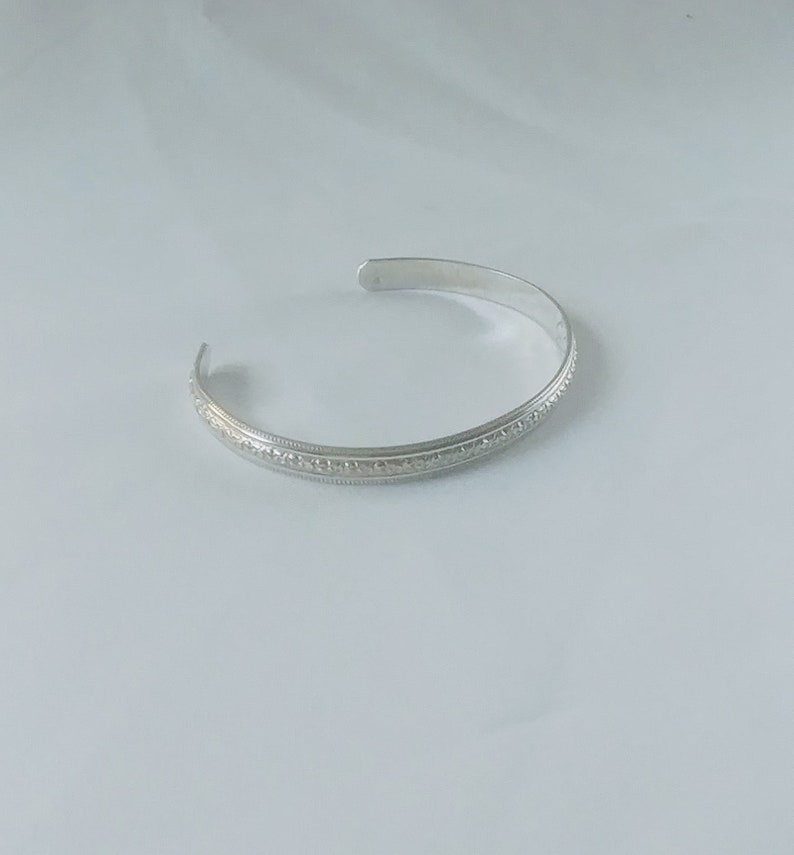 Sterling silver cuff with flowers that cover this very pretty bracelet that has a fluted edge, part of the Love Collection image 1