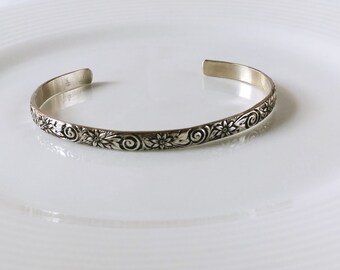 Sterling Silver cuff bracelet with flower swirl pattern and details with an oxidization highlight, part of the Love Collection