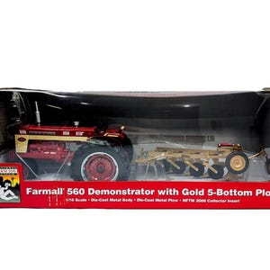 May include: A 1/16 scale die-cast Farmall 560 Demonstrator tractor with a gold 5-bottom plow, packaged in a red box. The box features the text Farmall 560 Demonstrator with Gold 5-Bottom Plow, 1/16 Scale, Die-Cast Metal Body, and NFTM 2008 Collector Insert.