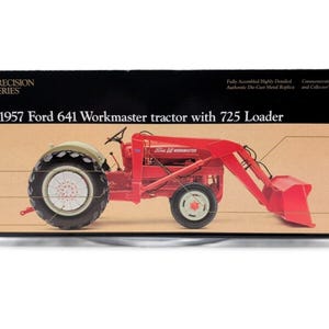May include: A red 1957 Ford 641 Workmaster tractor with a 725 Loader. The tractor is a die-cast metal replica and comes with a commemorative Ford booklet and collector's medallion.