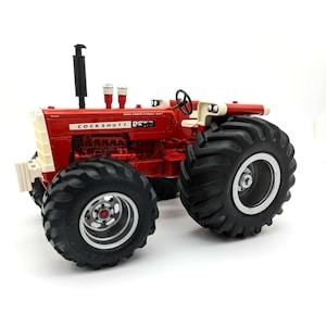 May include: A red and white Cockshutt 2553 tractor with large black tires. The tractor has a diesel engine and an over-under hydraulic shift.