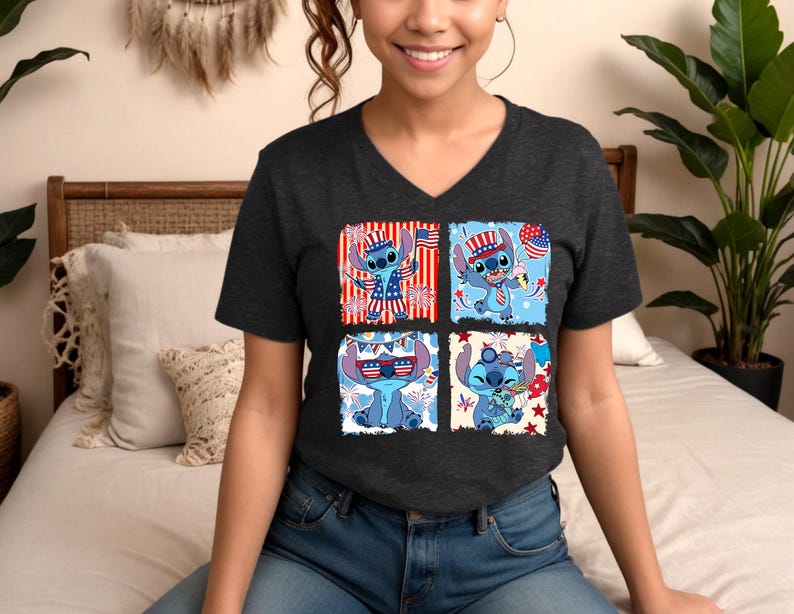 Puede incluir: Camiseta gris oscuro con cuello en V con un dise&ntilde;o de cuatro paneles de un personaje de dibujos animados azul con atuendo patri&oacute;tico. Cada panel muestra al personaje con elementos de la bandera estadounidense, fuegos artificiales y conos de helado.