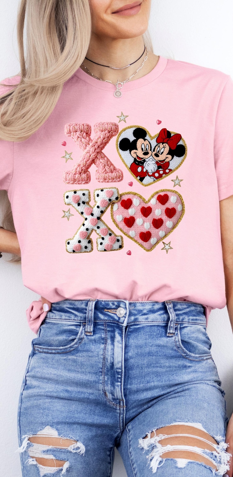 May include: Pink t-shirt featuring the letters "XO" in a knitted style, along with a heart-shaped design with Mickey and Minnie Mouse. The shirt also includes a heart-shaped design with red hearts and white polka dots.