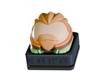 May include: A custom keycap featuring a stylized character with a light skin tone, orange hair, and a brown beard. The keycap sits on a dark gray base with the word "ABKE" printed on the front.