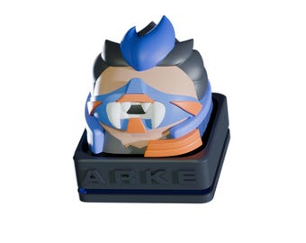 May include: A stylized, colorful keycap featuring a character design with blue, orange, and gray accents. The keycap sits on a dark gray base with the text "ARKE" in white. The design is reminiscent of a video game character.