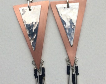 Pendientes triangulares de cobre y plata de ley con acabado martillado y cuentas de semillas negras.