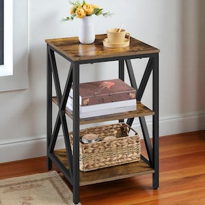 May include: A three-tiered side table with a rustic brown tabletop and shelves, supported by a black metal frame. The top shelf holds a white vase with yellow flowers and a yellow teacup. The middle shelf has books, and the bottom shelf has a woven basket.