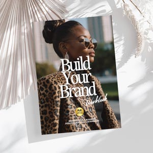 Op de afbeelding: Een zwart-wit luipaardprint jack met de tekst "Build Your Brand Workbook" in wit. De tekst "PLR Rights Included" staat in een gouden cirkel met een zwarte rand. De tekst "Branding Your Business Designed for Small Businesses" staat in zwarte tekst onder de cirkel.