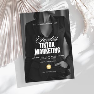 May include: A book cover with the title "Faceless TikTok Marketing" in white and black text. The cover features a person in a black blazer. The text includes "How can I sell online with a faceless account on TikTok" and "Create passive income."