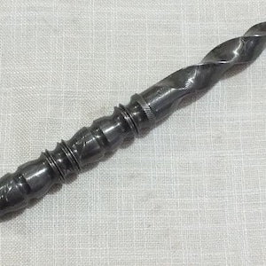 May include: A twisted, silver-coloured metal dagger with a decorative handle. The handle is made of multiple sections, each with a different pattern.