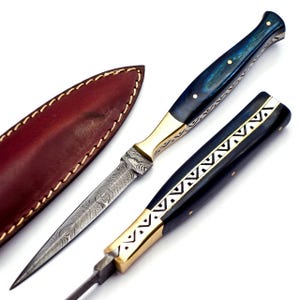 May include: A Damascus steel knife with a blue and gold handle and a leather sheath. The handle has a geometric pattern.