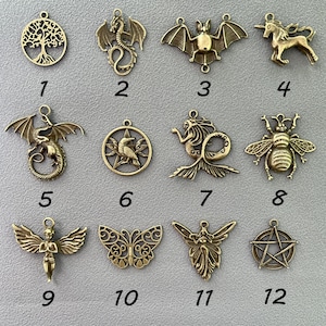 May include: Twelve gold-toned metal charms with various designs, including a tree of life, dragon, bat, unicorn, bee, mermaid, butterfly, and a pentagram. Each charm is numbered 1 through 12.