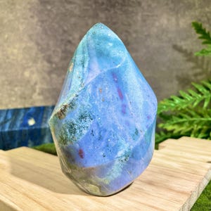 以下が含まれることがあります： 青、緑、紫の瑪瑙の結晶ポイントで、ユニークな渦巻き模様をしています。結晶は研磨されており、滑らかで光沢のある仕上がりです。