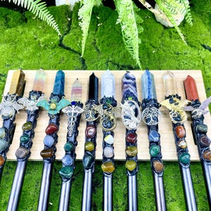 May include: Twelve wands with different crystal points and metal accents. Each wand has a different crystal point, including amethyst, clear quartz, tiger's eye, and more. Each wand also has a different metal accent, including a dragon, a bat, and a tree of life.
