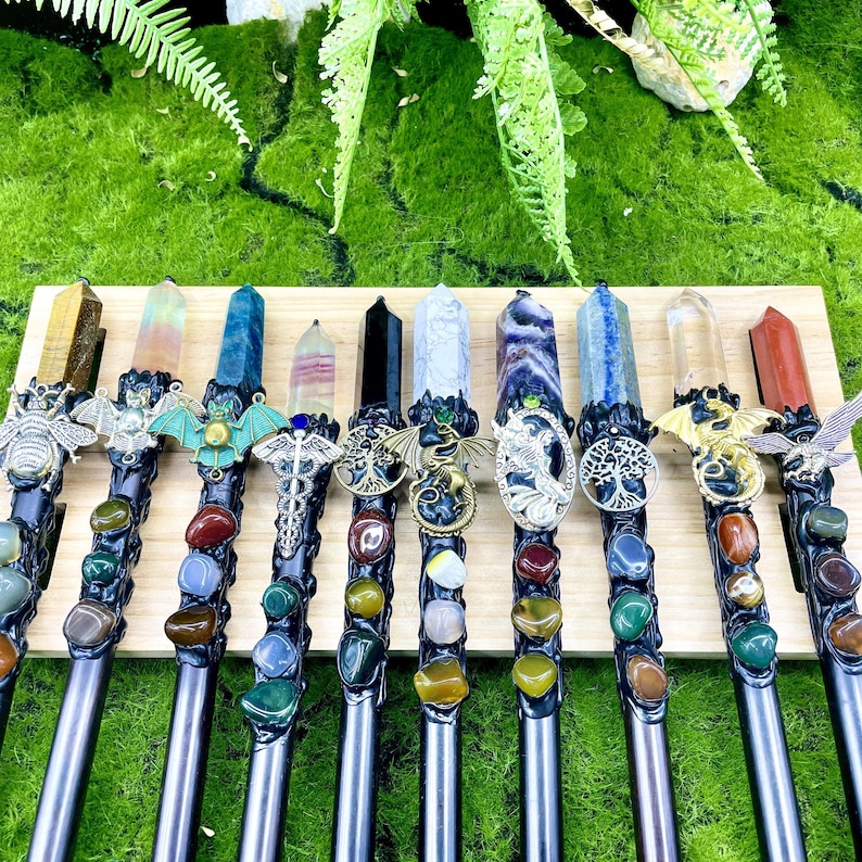 May include: Twelve wands with different crystal points and metal accents. Each wand has a different crystal point, including amethyst, clear quartz, tiger's eye, and more. Each wand also has a different metal accent, including a dragon, a bat, and a tree of life.