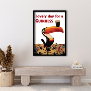 May include: A vintage Guinness advertisement featuring a toucan holding a glass of Guinness with the text "Lovely day for a GUINNESS".