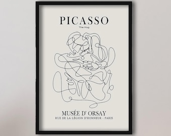 May include: A framed wall art print featuring a black single-line drawing of two figures embracing. The text reads PICASSO The Hug, MUSÉE D' ORSAY, RUE DE LA LÉGION D'HONNEUR - PARIS. The background is off-white, and the frame is black.