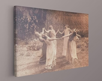 May include: A rectangular canvas print featuring a sepia-toned photograph of five individuals in long, flowing dresses standing in a circle outdoors, holding hands and looking upward in a grassy garden setting with trees and foliage in the background.