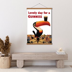 May include: A vintage poster featuring a toucan holding a glass of Guinness beer. The poster reads "Lovely day for a GUINNESS".