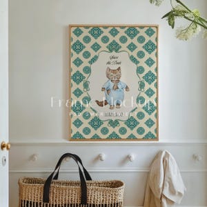 May include: A framed print with a green and cream patterned background. The print features a cartoon cat wearing a blue shirt and the text "Save the Date".