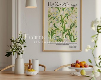 May include: A framed print with a floral design featuring white flowers and green leaves. The print is titled "HANACO" and is displayed on a white wall in a dining room setting.