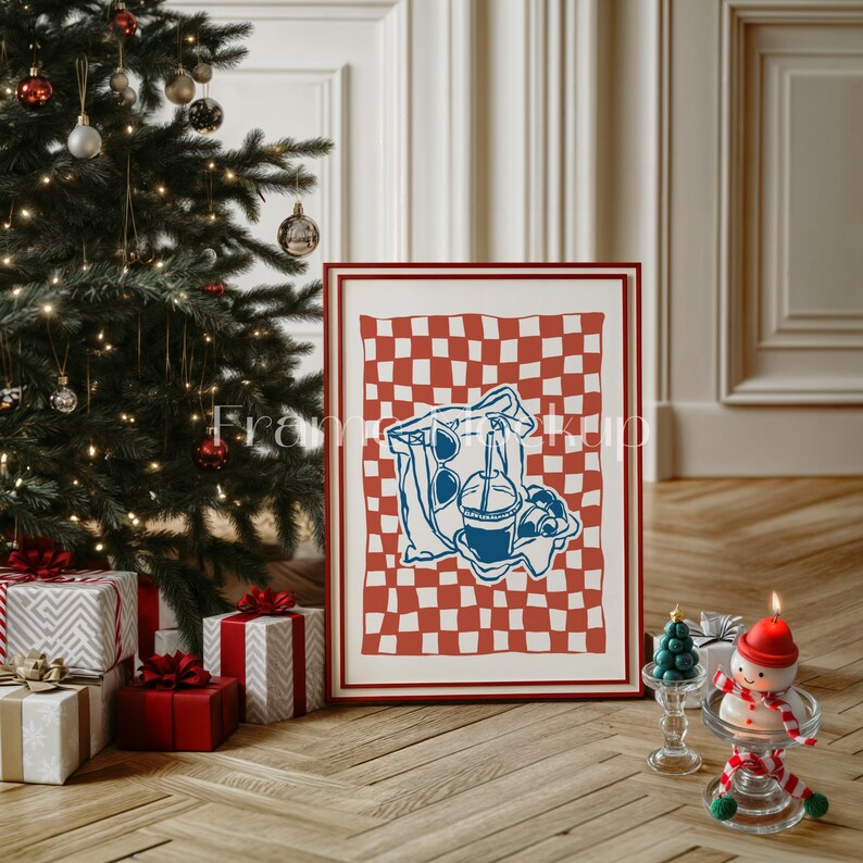 K&ouml;nnte beinhalten: Ein gerahmter Druck eines rot-wei&szlig; karierten Picknick-Decken mit einer blauen Illustration einer Tasche, einer Sonnenbrille und einem Getr&auml;nk mit einem Strohhalm. Der Druck h&auml;ngt an einer wei&szlig;en Wand neben einem Weihnachtsbaum.