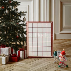K&ouml;nnte beinhalten: Ein roter Rahmen mit wei&szlig;em Hintergrund und einem Gittermuster. Der Rahmen steht auf einem Holzboden vor einem Weihnachtsbaum, der mit roten und goldenen Kugeln geschm&uuml;ckt ist. Eine Schneemannkerze und ein kleiner Weihnachtsbaum stehen auf dem Boden vor dem Rahmen.