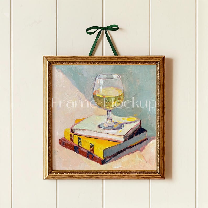 Puede incluir: Una pintura enmarcada de una copa de vino blanco sentada encima de una pila de libros. Los libros son amarillos, rojos y azules. El fondo es azul claro y blanco.