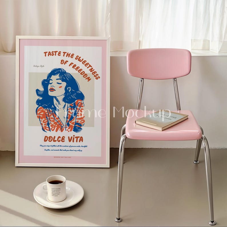 Puede incluir: Un p&oacute;ster enmarcado blanco con fondo rosa y una ilustraci&oacute;n colorida de una mujer con el texto "Taste the Sweetness of Freedom" y "Dolce Vita". Una silla rosa con un libro en el asiento y una taza de caf&eacute; en un platillo blanco est&aacute;n en primer plano.