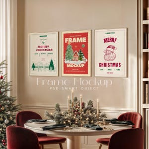 May include: Three framed Christmas-themed posters with red, green, and white designs. The posters are hanging on a beige wall above a white table with a centerpiece of greenery and candles. The table is set with two place settings, each with a plate, napkin, and silverware.