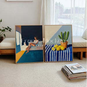 Puede incluir: Dos pinturas enmarcadas, una representa a una mujer sentada en un sofá con un gato, y la otra muestra un cactus en una maceta con limones sobre una mesa a rayas azules y blancas.