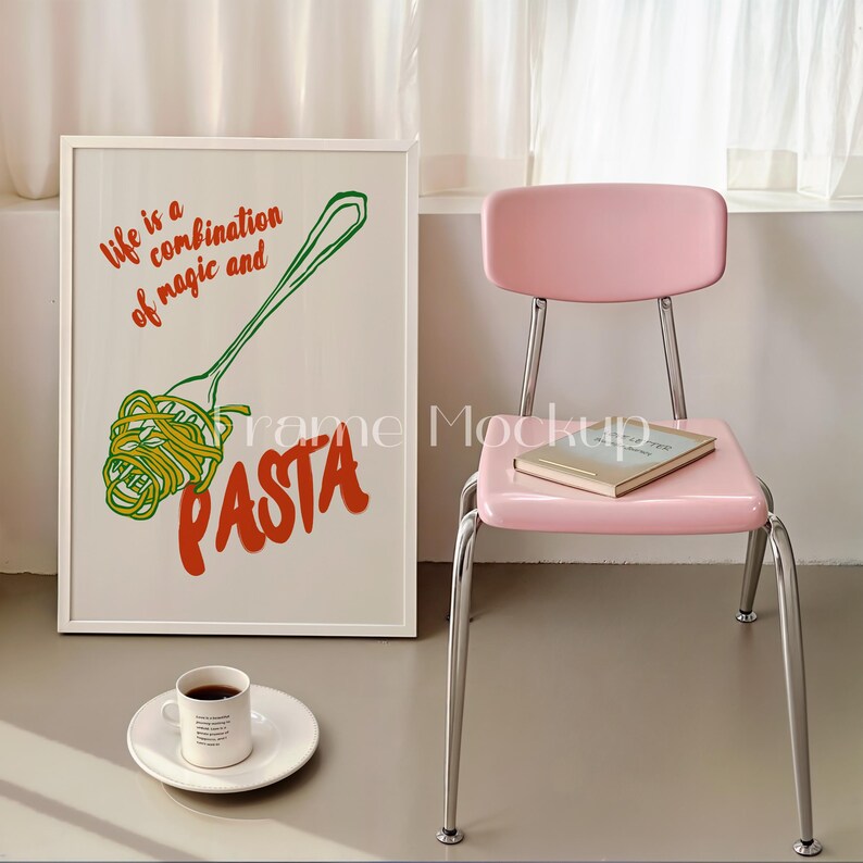 Puede incluir: Una impresi&oacute;n enmarcada en blanco con el texto "Life is a combination of magic and pasta" en letras de colores. La impresi&oacute;n presenta una ilustraci&oacute;n de dibujos animados de un tenedor con pasta encima. La impresi&oacute;n est&aacute; colgada en una pared junto a una silla rosa con un libro encima.