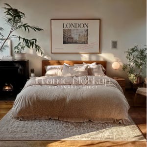 May include: A bedroom featuring a bed with a beige duvet cover featuring a white floral pattern. The bed has a wooden headboard and is styled with white and beige pillows. A framed poster with the word "LONDON" printed on it hangs on the wall above the bed. A lamp with a white globe sits on a bedside table next to the bed. A rug with a light brown and white pattern is on the floor in front of the bed.