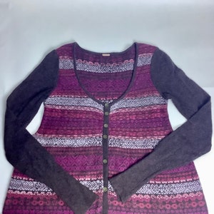 May include: A long-sleeved, purple and brown patterned cardigan with a scoop neck and button closure.