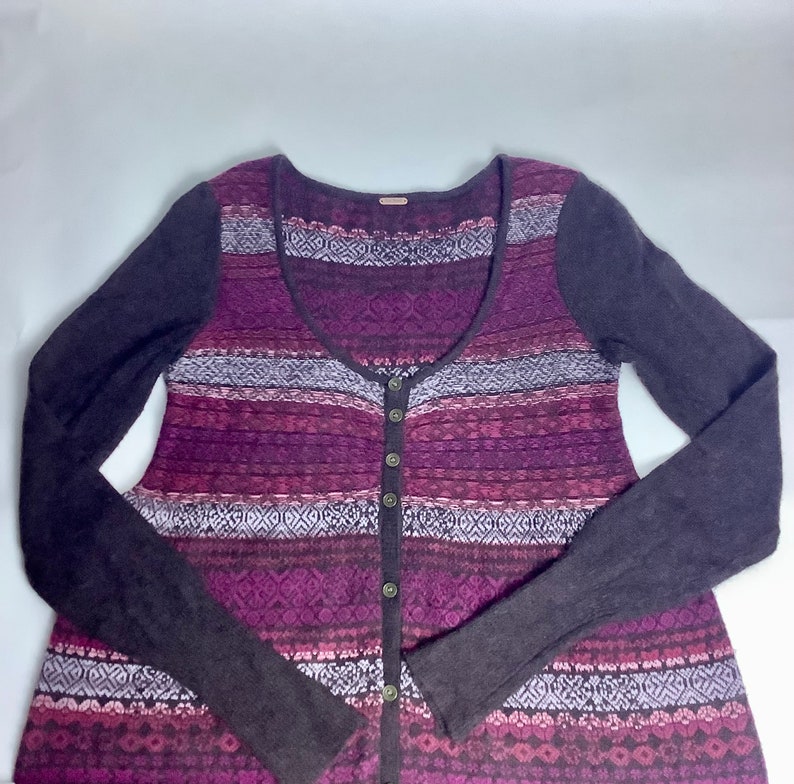 May include: A long-sleeved, purple and brown patterned cardigan with a scoop neck and button closure.