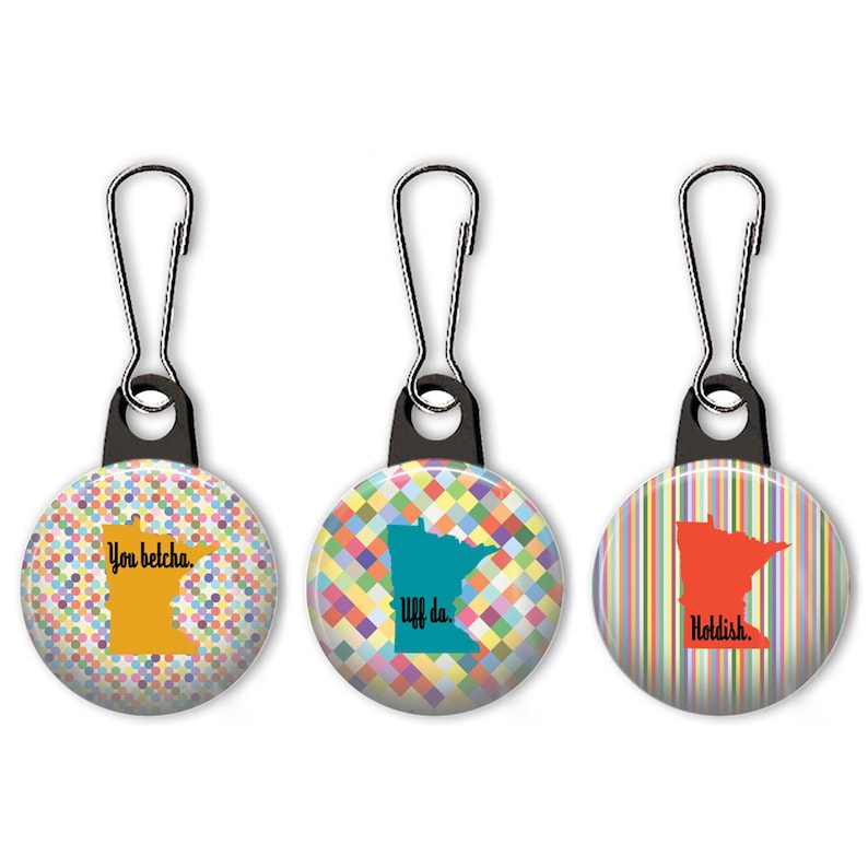 May include: Three zipper pulls with colorful patterned circles, each featuring an outline of the state of Minnesota and a phrase: "You betcha.", "Uff da.", and "Holddish."
