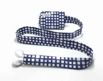 TuneTube earbud cord organizer for iPhone or iPod.  Cord keeper. Earbud holder. Earbud case.  Navy blue and white abstract squares.