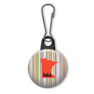 May include: A colorful striped button with a red outline of the state of Minnesota and the text "Holdish." The button is attached to a black zipper pull.