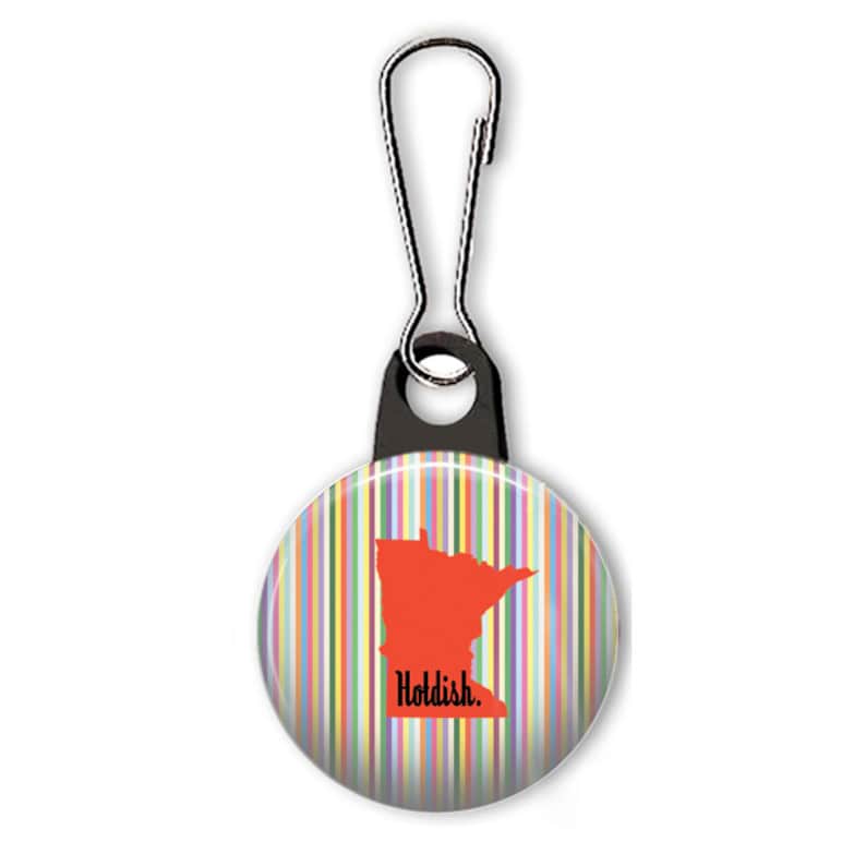 May include: A colorful striped button with a red outline of the state of Minnesota and the text "Holdish." The button is attached to a black zipper pull.