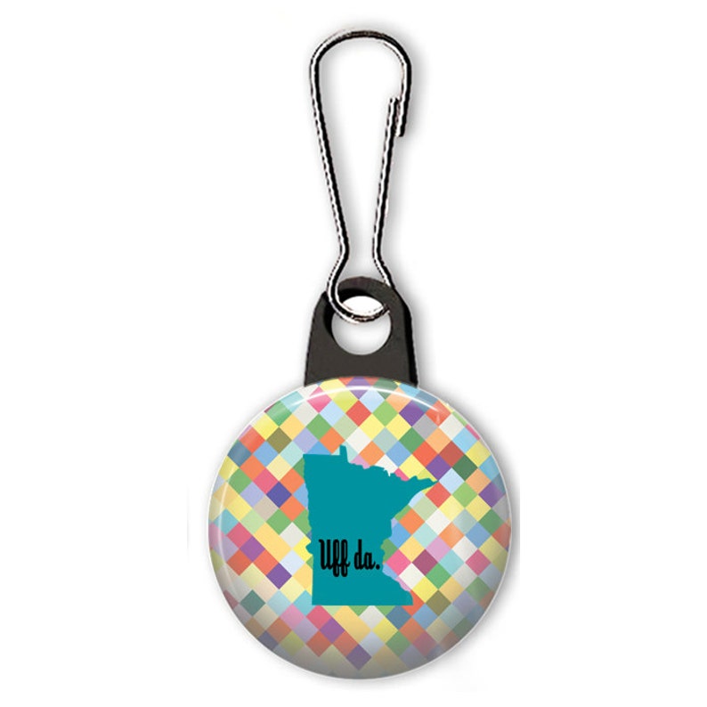 May include: A colorful zipper pull featuring a teal outline of the state of Minnesota with the text "Uff da." on a background of colorful squares.