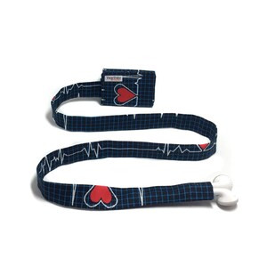 May include: A black and blue fabric lanyard with a red heart and EKG pattern. The lanyard has a white plastic badge holder and a white plastic breakaway clasp.