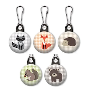 May include: Five zipper pulls with different woodland animal designs. The animals are a raccoon, fox, hedgehog, squirrel, and bear. Each zipper pull has a black and white houndstooth pattern.
