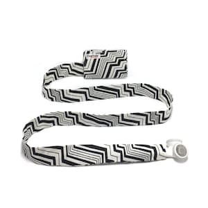 May include: A black and white zig-zag patterned lanyard with a small black and white patterned pouch attached. The lanyard has a white plastic clip on one end.