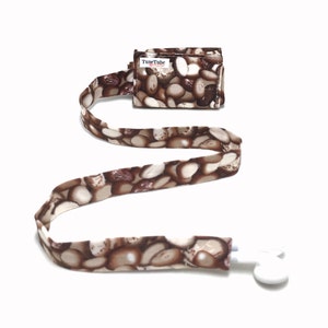 May include: A brown and white patterned lanyard with a white plastic clip and a small brown and white patterned pouch with the text "TuneTube" printed on it.