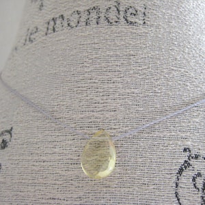 Puede incluir: Un collar sencillo con un solo colgante en forma de l&aacute;grima de vidrio amarillo transparente.