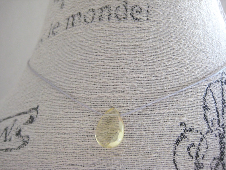 Puede incluir: Un collar sencillo con un solo colgante en forma de l&aacute;grima de vidrio amarillo transparente.