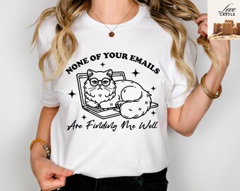 May include: White t-shirt with a black and white illustration of a cat wearing glasses and sitting on a laptop. The text "None of your emails are finding me well" is printed on the shirt.